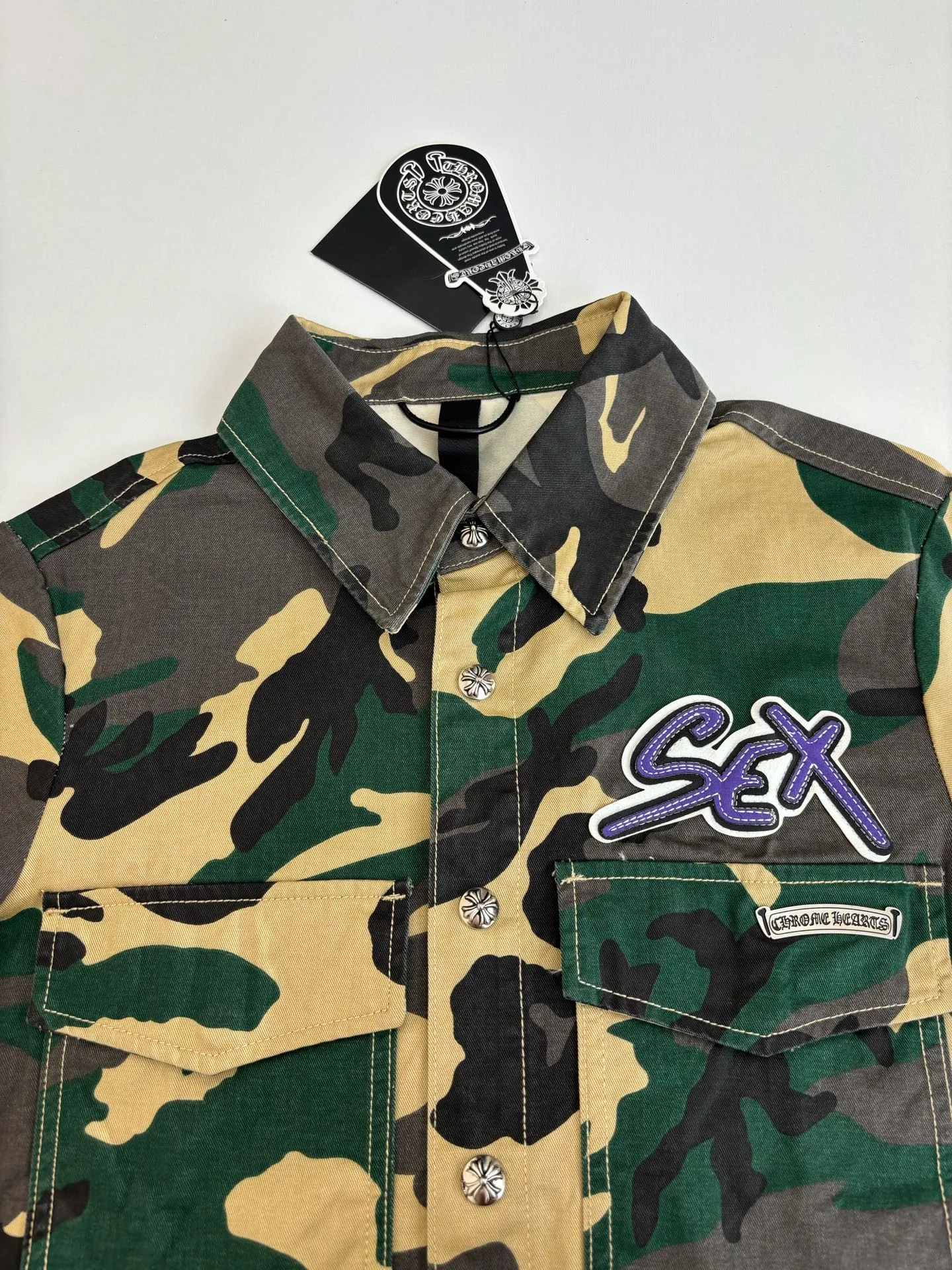 P560 Chrome Heart*/Chrome Heart CH camouflage short-sleeved denim shirt was purchased and developed by a Los Angeles agent for US$3,200. This model is made of customized military canvas fabric, restored 1:1 according to the original model, and printed with camouflage patterns. The customization period for the chest sex pattern stamp is 20 days, the minimum order is 1800 pieces, and the color plate is matched. The hardware buckles are all made of electroplated 925 silver material, the weight is perfectly restored, and they are aged and oxidized to black.  Size：S/M/L
